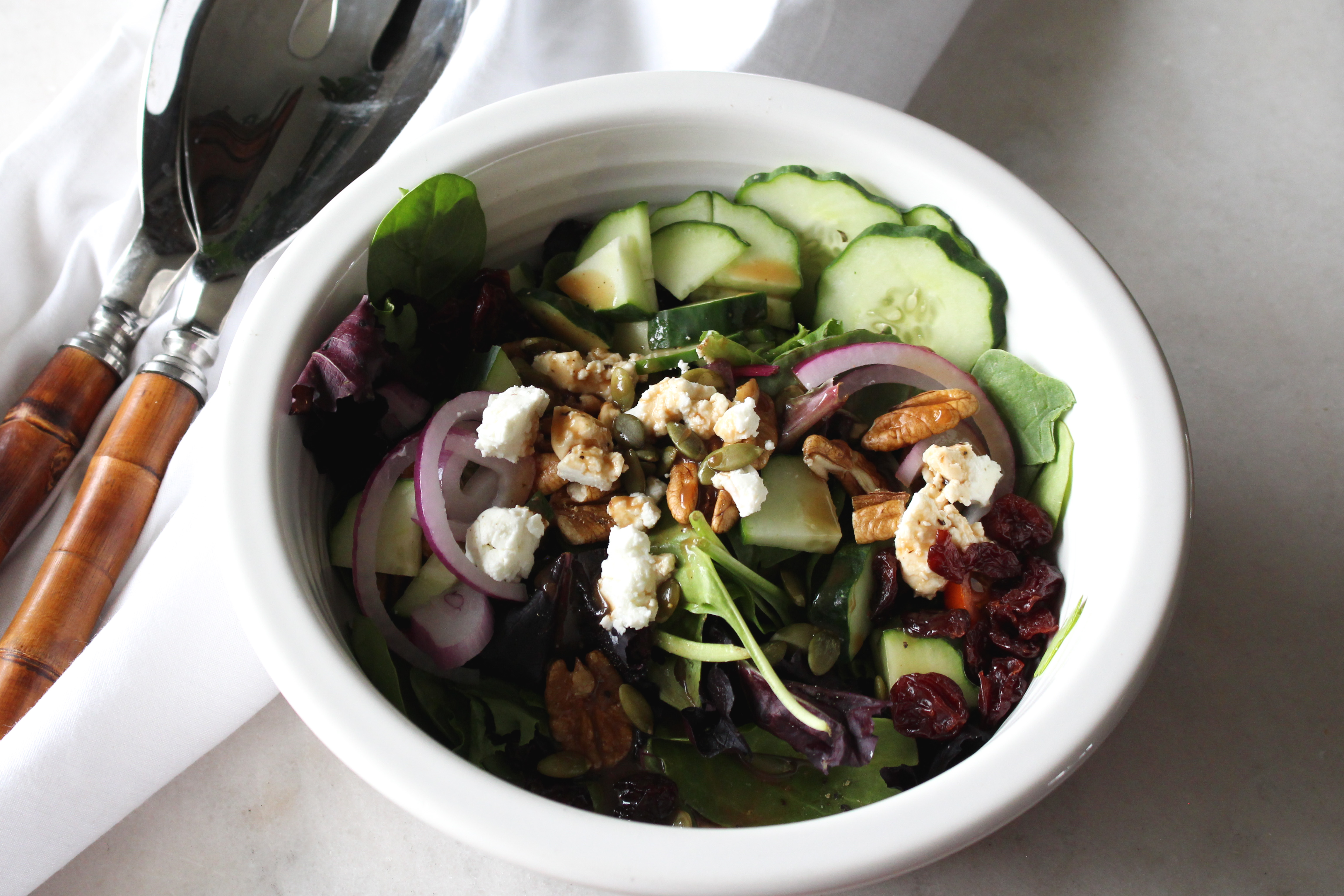Garden fresh salad with baby greens, cucumbers, red onion, pecans, goat cheese and balsamic dressing