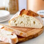 A sliced loaf of artisan sourdough bread on a cutting board.