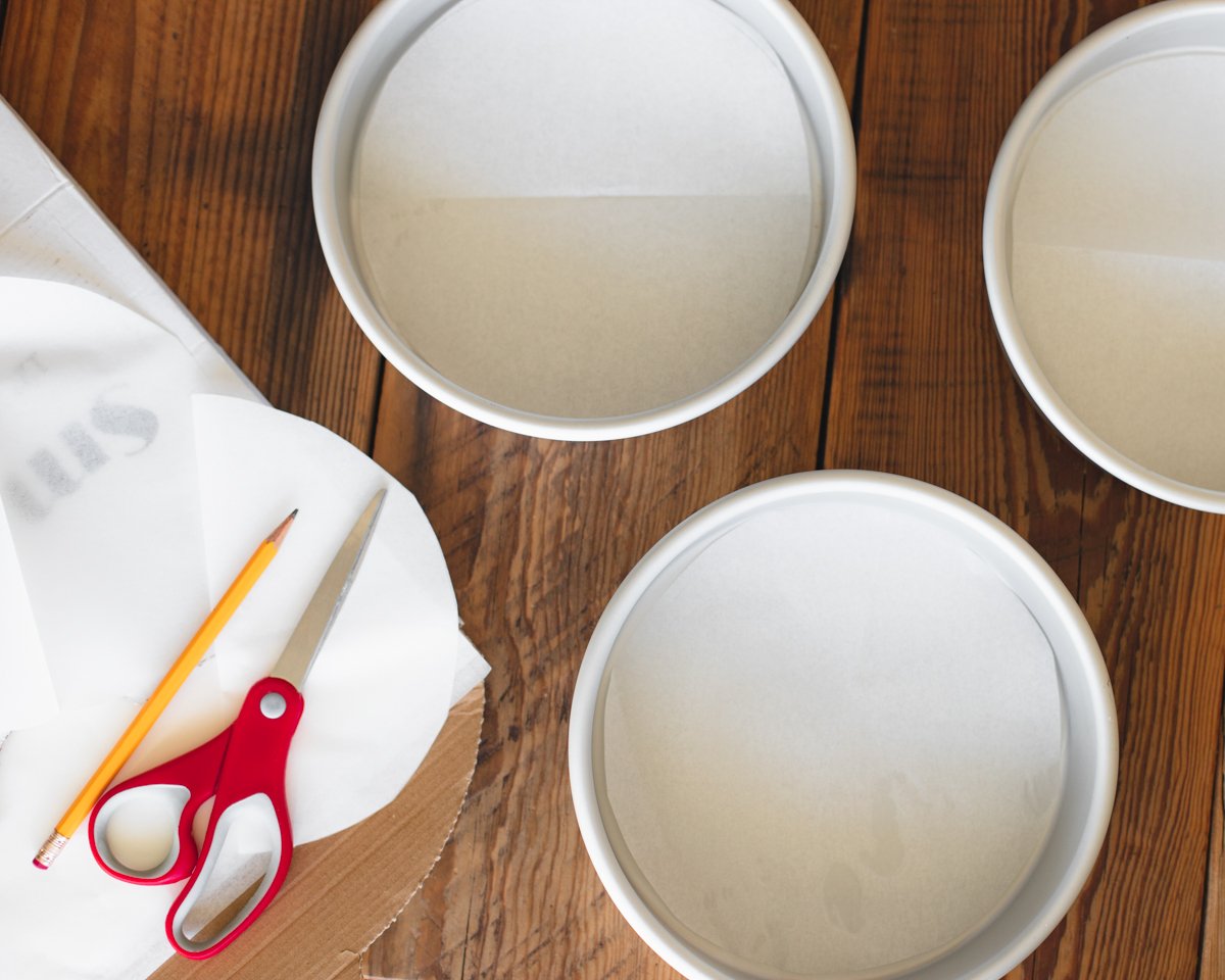 An image showing how to line baking pans with parchment paper to prevent cakes from sticking.