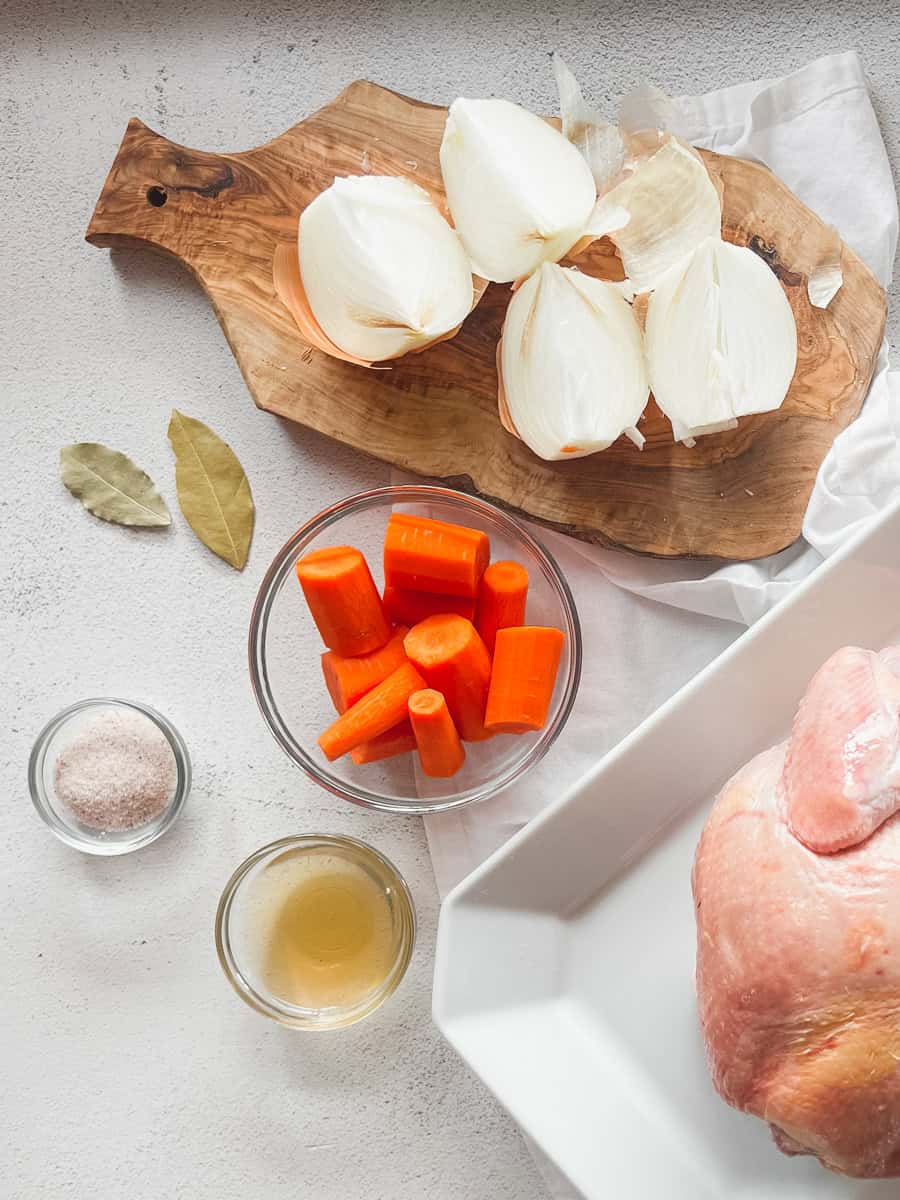 Chicken broth aromatics including carrots, bay leaves, onion and salt.