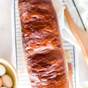 A fresh baked loaf of homemade big sandwich bread on a cooling rack.