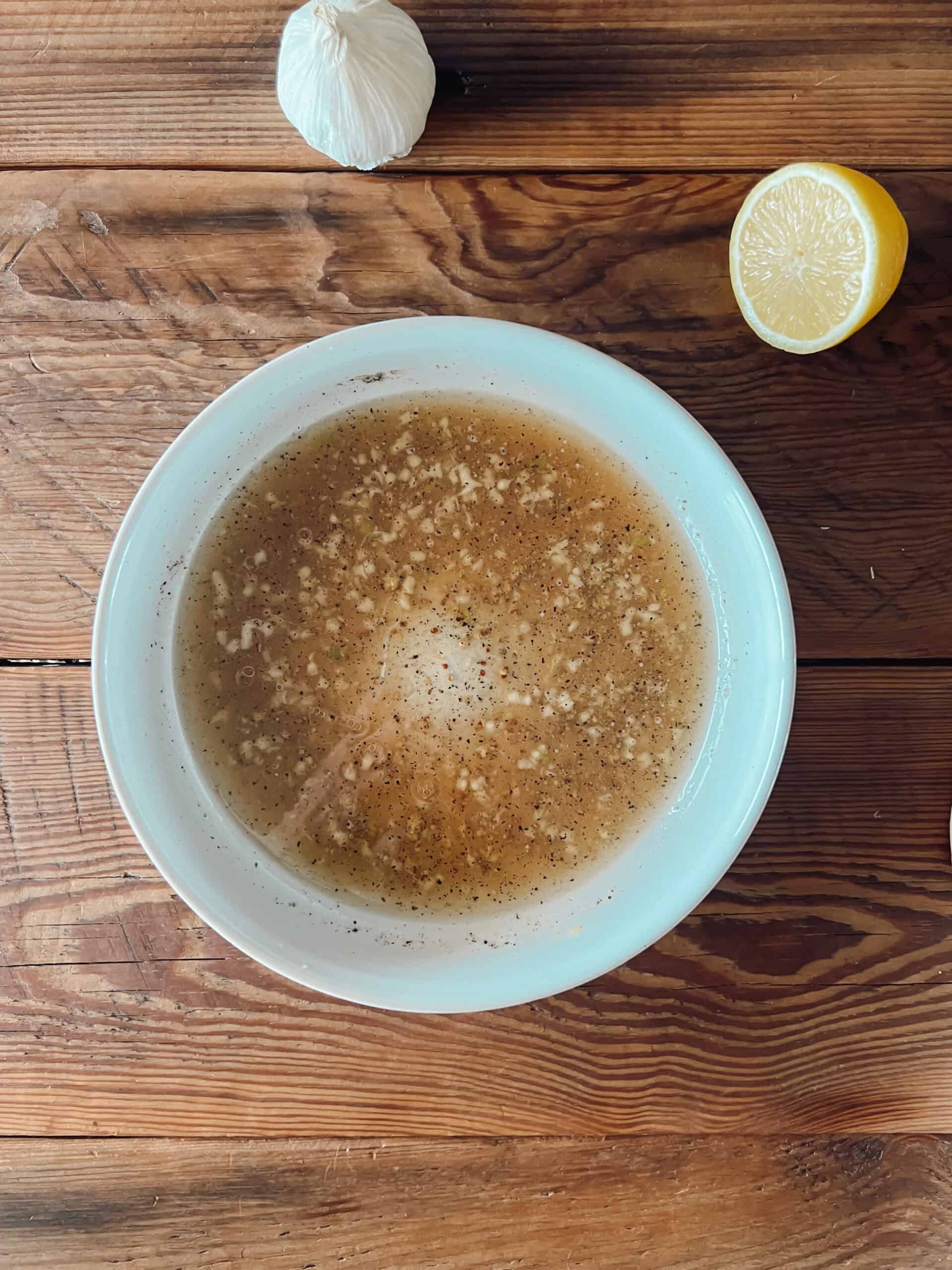 A white bowl filled with the ingredients for all-purpose venison marinade.