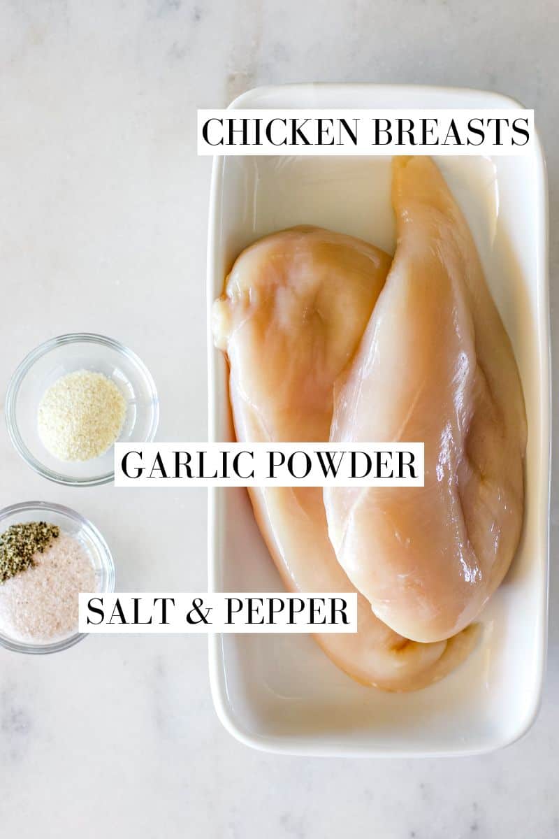 A top view of ingredients for air fryer chicken breasts including chicken, salt, pepper, garlic powder.