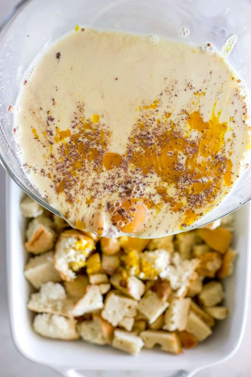 An image of step three of making sourdough bread pudding: Pour the egg mixture over the bread.
