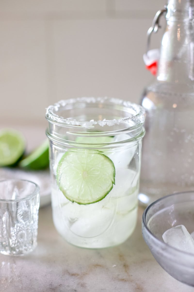step three of making ranch waters, adding lime juice to the glass of tequila and ice.