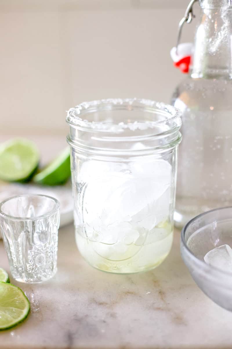step two for making ranch waters, a glass filled with ice and one shot of tequila.