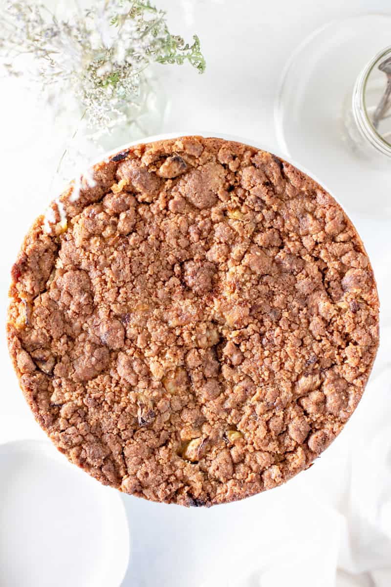 A top down view of a sour cream cake with crumble topping.