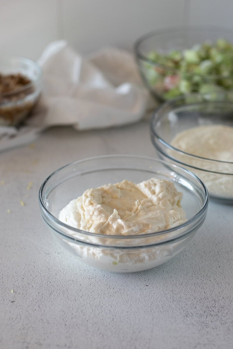 Step three for making a rhubarb sour cream cake is creaming the sugar, butter, egg and vanilla in a mixing bowl.