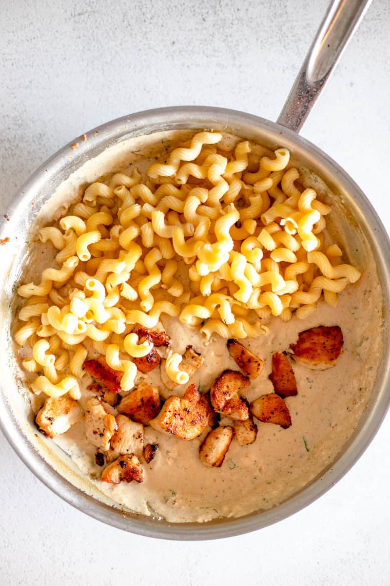 Step 7 of making Loaded Marry Me Chicken pasta is adding the cooked pasta and chicken to the cream sauce.