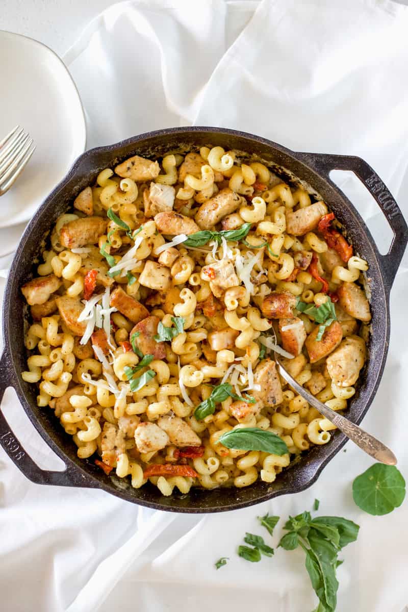 A cast iron skillet with marry me chicken pasta that is finished cooking.