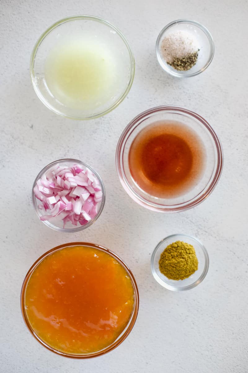 Ingredients for apricot dressing in prep bowls on a white background.