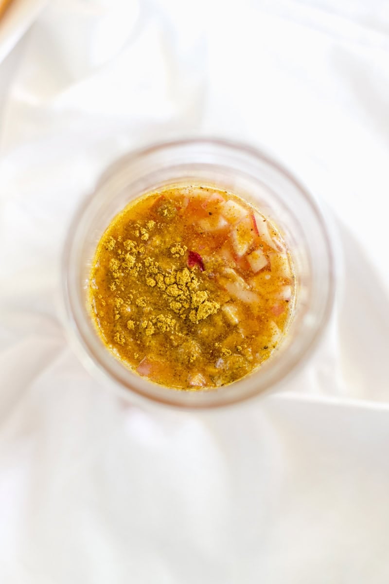 A glass mason jar with the ingredients of apricot dressing ready to be blended.