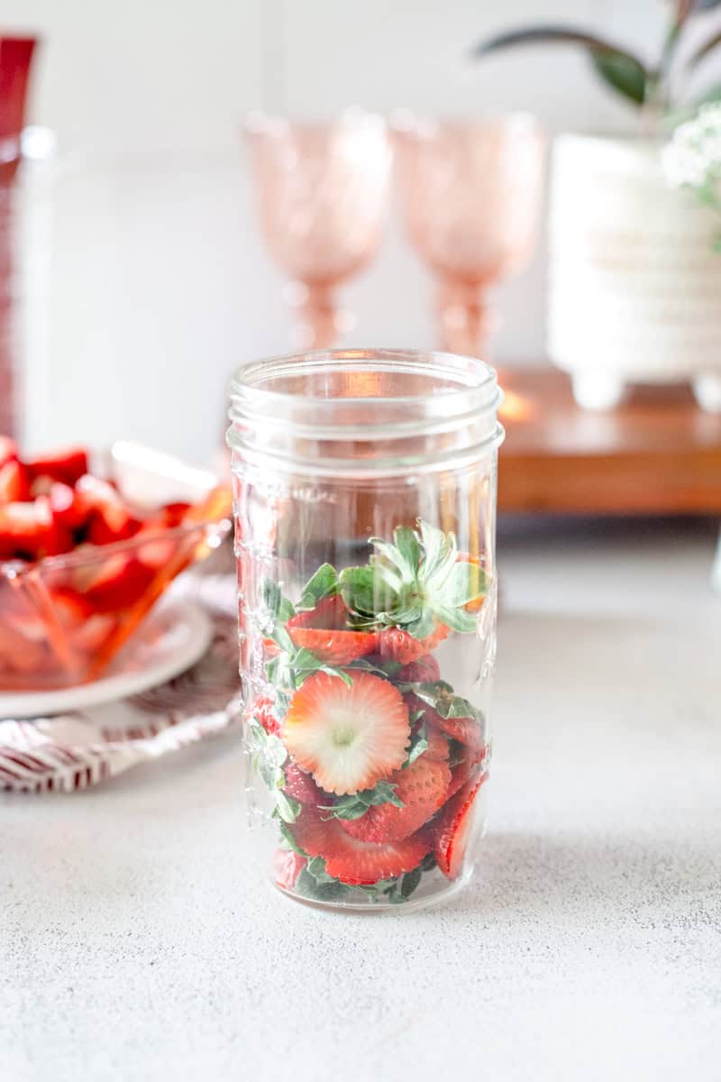 Step one: put the strawberry tops in a mason jar.