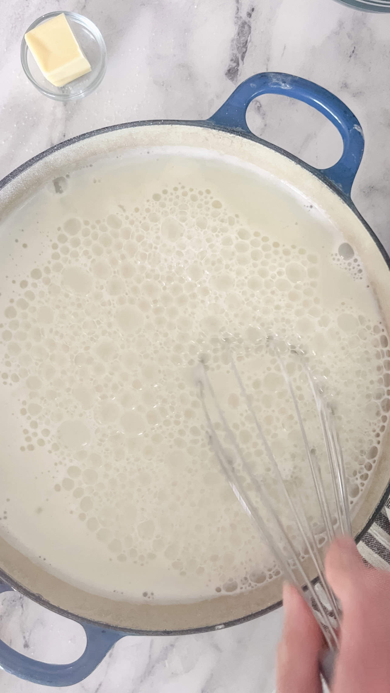 Step one of making homemade pudding is whisking together the sugar and cornstarch and then pouring it into the milk in a dutch oven.