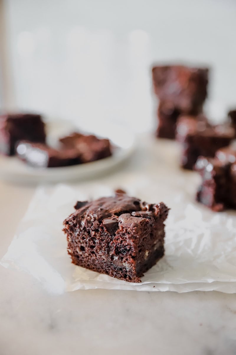 A white parchment with sliced SOURDOUGH DISCARD CHOCOLATE BANANA BREAD BARS.
