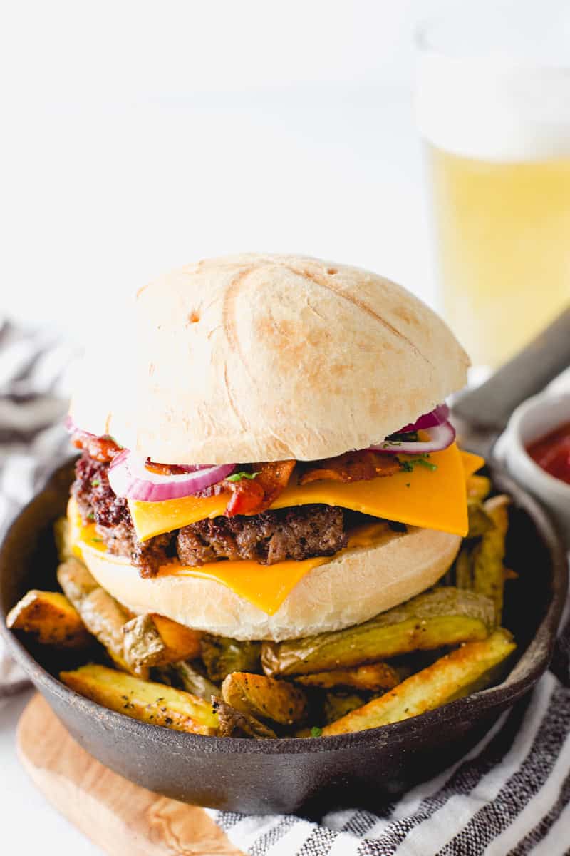 Best Venison Burgers (ground deer meat burger) in a mini cast iron skillet with oven fries.