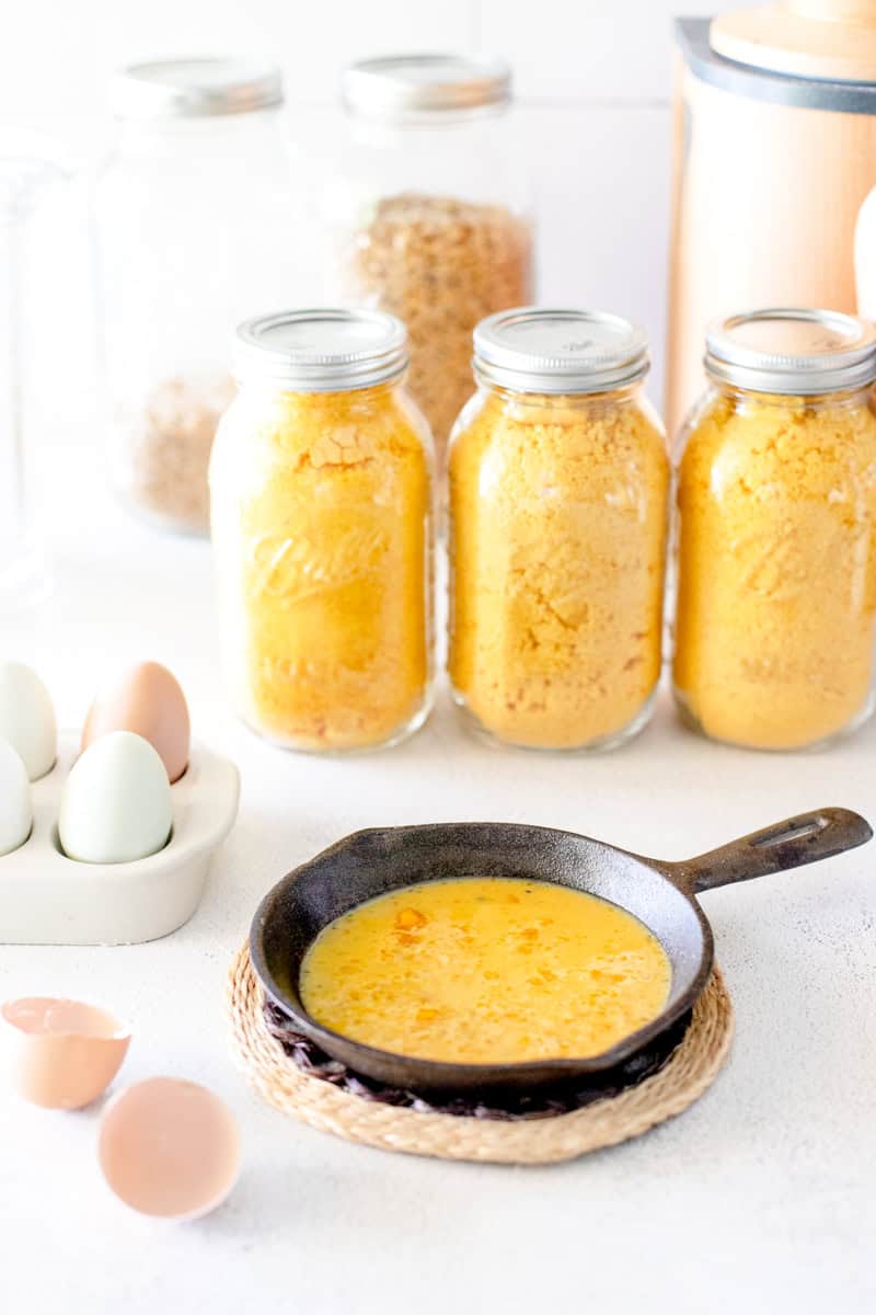 Freeze dried eggs in mason jars that have been ground into an egg powder, and then a mini cast iron skillet showing what the eggs look like when reconstituted and cooked.