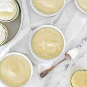 Bowls of homemade vanilla pudding on a marble background.