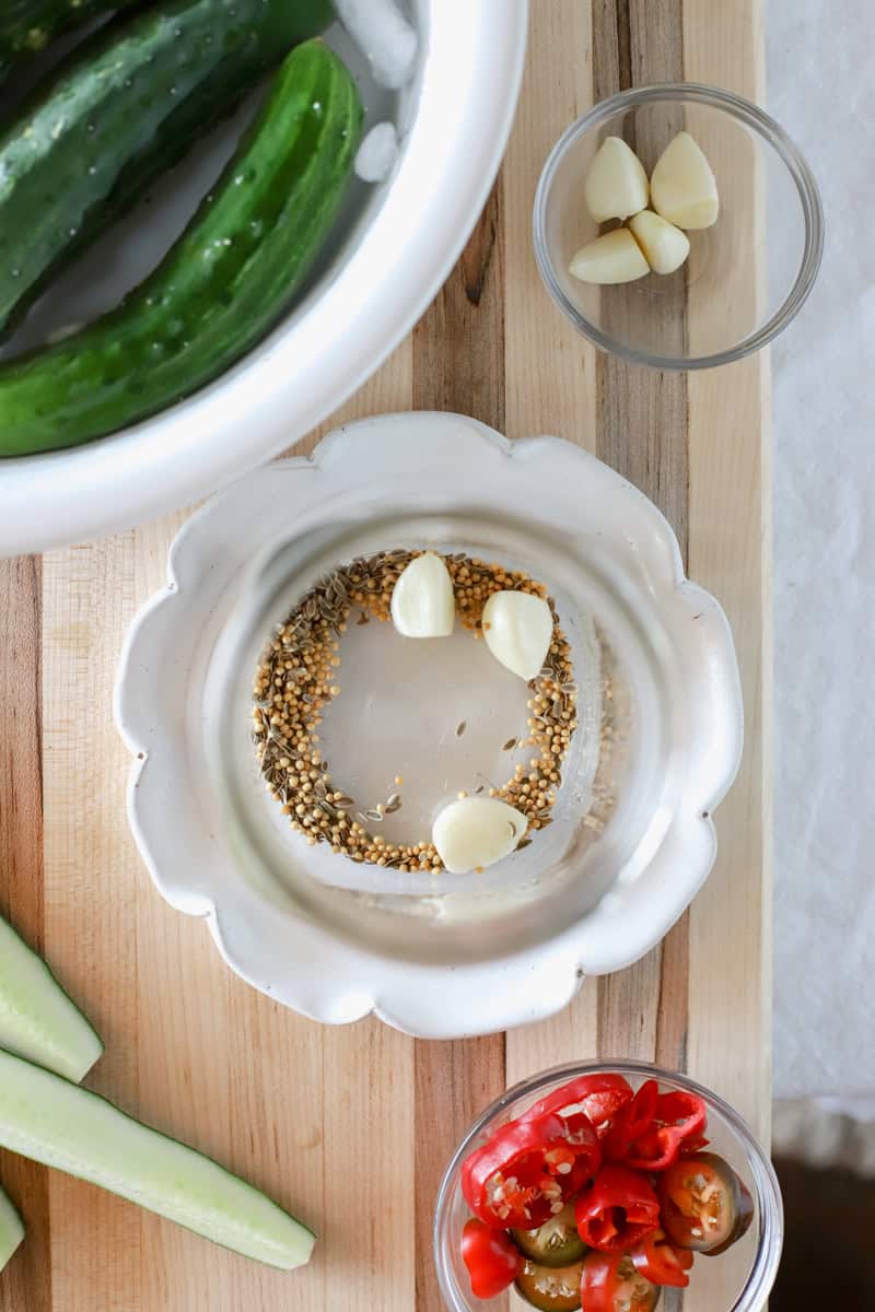 4. Divide the dill, garlic, mustard, and jalapeños or banana peppers evenly between the jars. Add the cucumbers to the jar, fitting them snugly together. Your jar should be packed nice and tight!