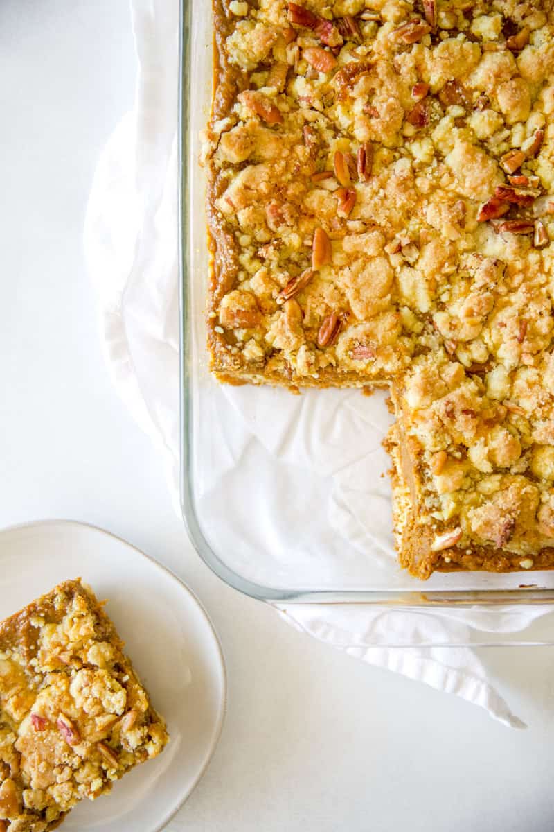 Old-Fashioned Pumpkin Crunch Cake recipe in a glass pan with a slice taken out of it.