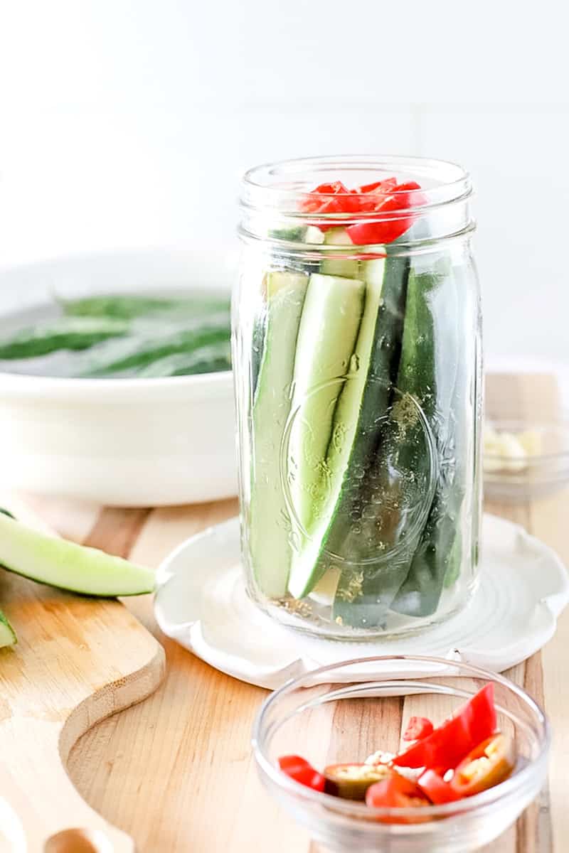 A jar of pickles that has been packed and is ready for the brine to be poured over.