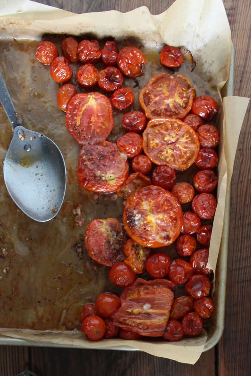 2. Place the tomatoes and peeled whole garlic cloves on the baking sheet. Drizzle generously with olive oil, season with salt and pepper. Roast until parts look slightly charred, about 25 minutes. I always rotate the pan and give it a stir after the first 15 minutes.