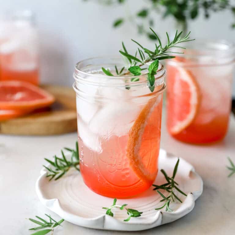Grapefruit Moscow Mule in a mason jar with a sprig of rosemary garnish.