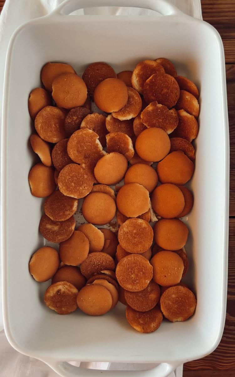 Step one of making banana pudding with vanilla wafers is spreading the wafers in the bottom of the pan.