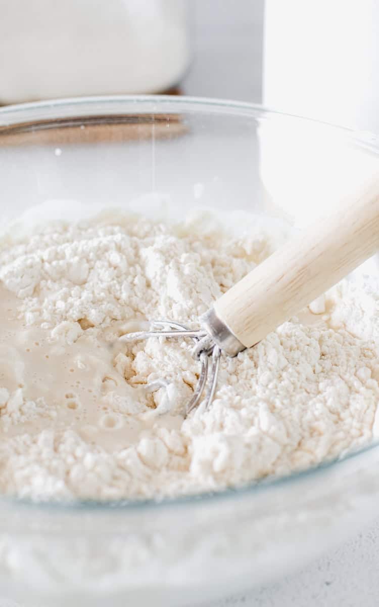 Step one of making sourdough bagels, combine ingredients in a large mixing bowl.