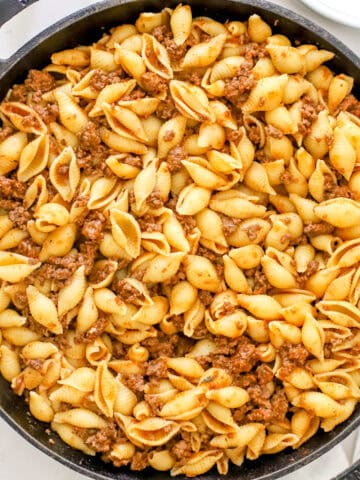 Close up view of venison goulash in a cast iron skillet.