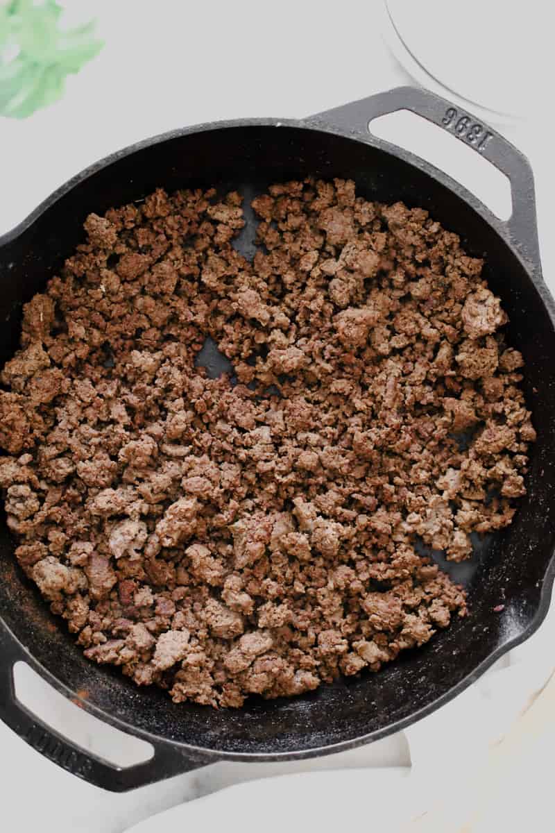 Browned ground venison in a skillet.