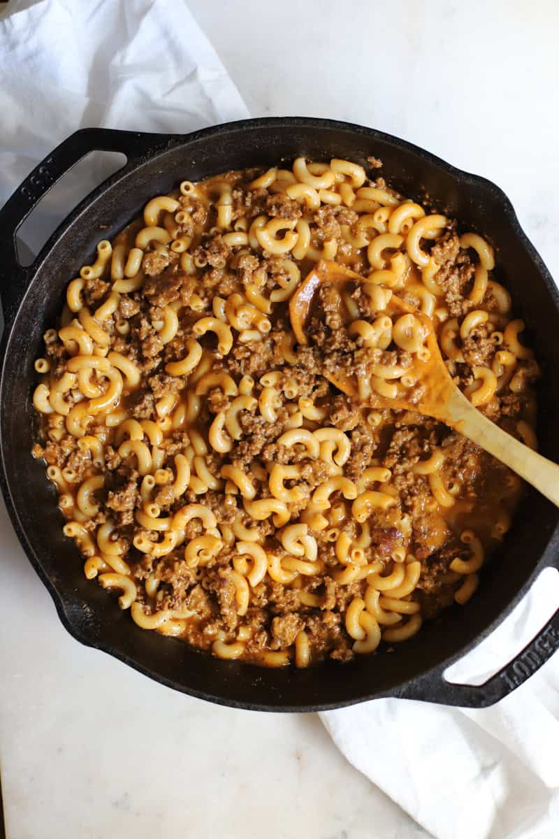 Step two of making venison hamburger helper is adding the noodles to the skillet.