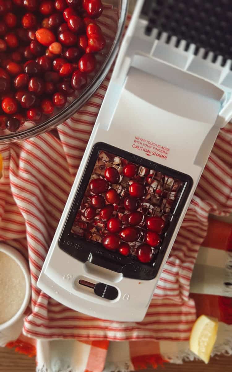 Step two of making dehydrated cranberries is using a food chopper to slice the cranberries into pieces.