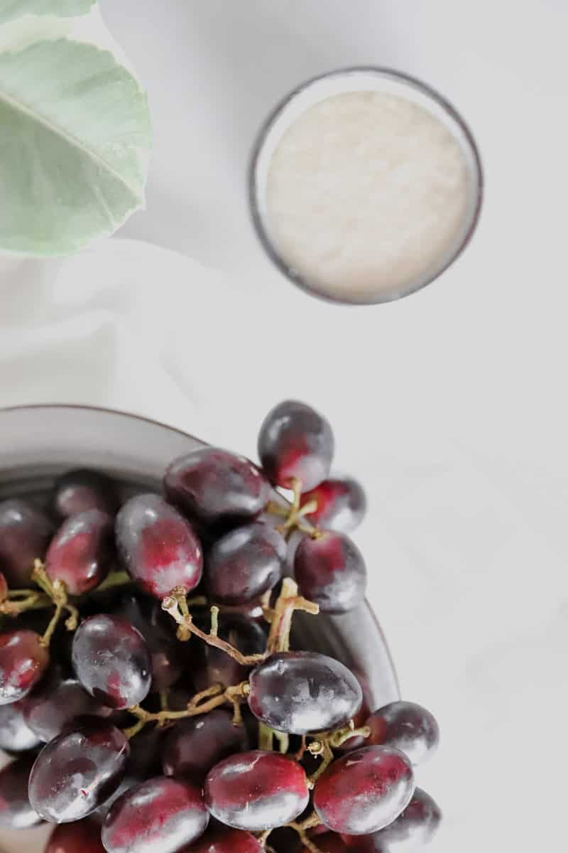 Top view of ingredients for homemade grape juice are grapes and sugar.