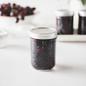 A pint jar of homemade grape juice from this grape juice canning recipe.