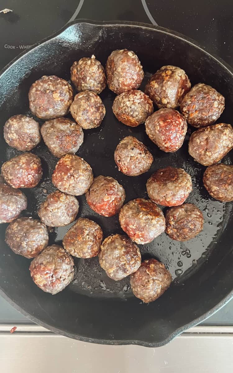 Step 3 of making venison meatballs in a cast iron skillet is browning the meat.