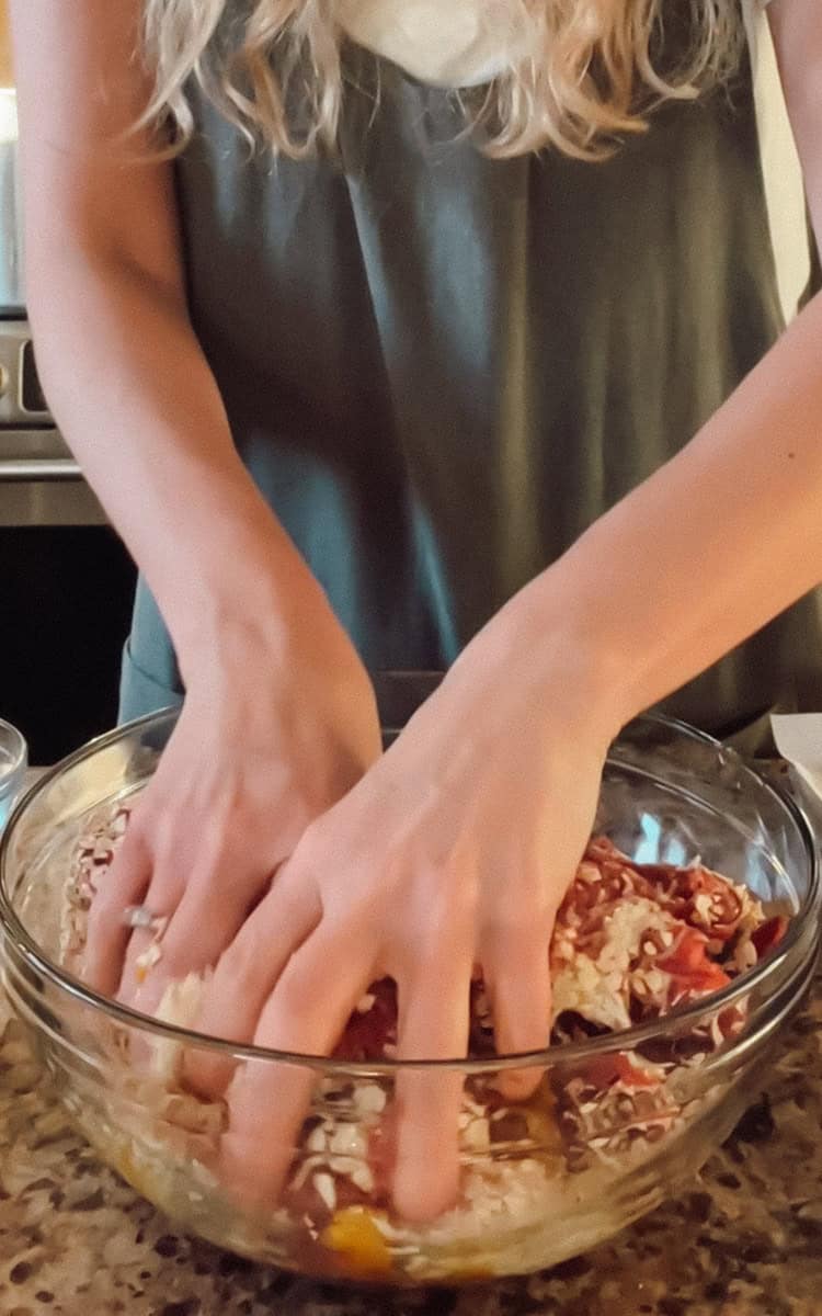 Step one of making venison meatballs is combining the ingredients in a bowl and mixing.