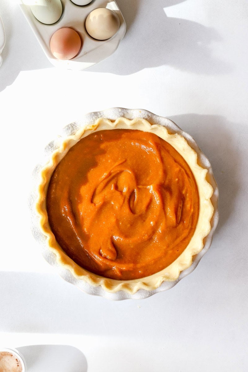 Step 4 of making a pumpkin pie is covering the edges with foil and putting it in the oven to bake.