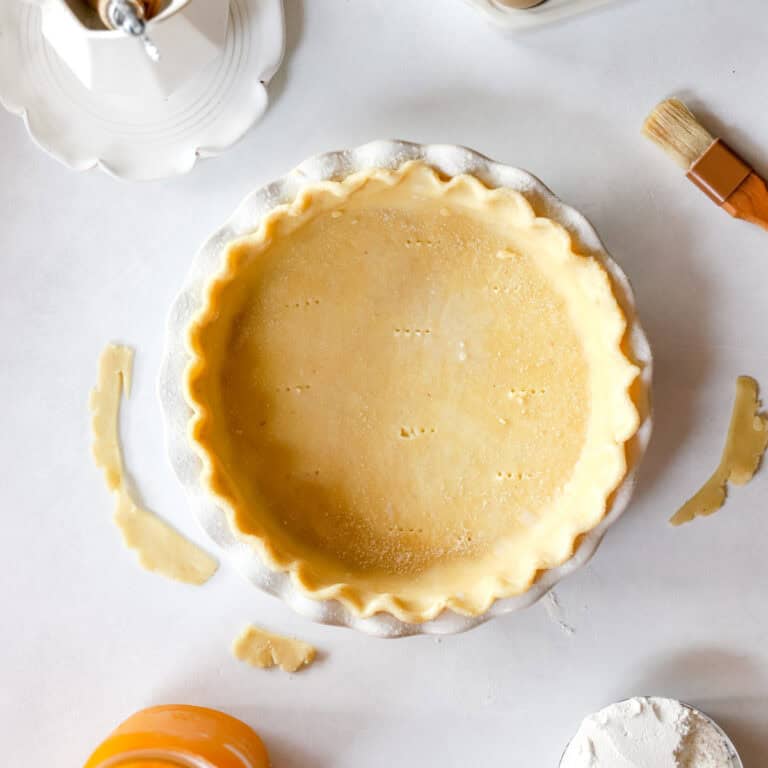 A close up view of sourdough pie crust in a pottery pie pan.