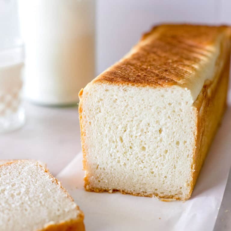 Sourdough sandwich bread made in a pullman pan, also known as pain de mie, that is sliced to show the tight crumb.