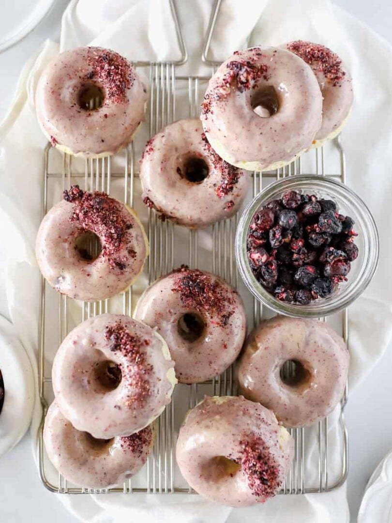 Blueberry donut recipe showing 12 donuts cooling on a wire rack.