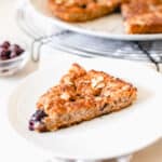 An aerial view of a sourdough coffee cake made with blueberries on a black metal wire cooling rack.