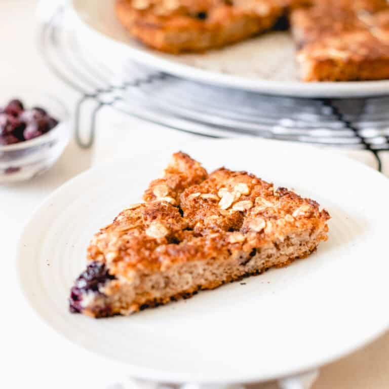 An aerial view of a sourdough coffee cake made with blueberries on a black metal wire cooling rack.