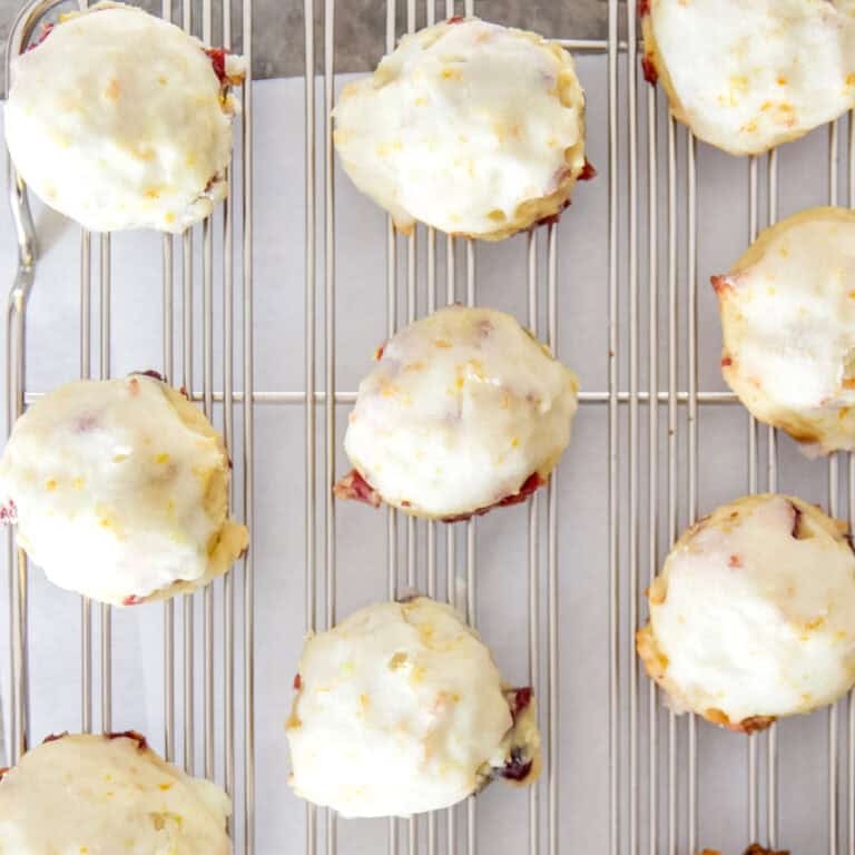 A close up view of cranberry orange cookies on a cooling rack.