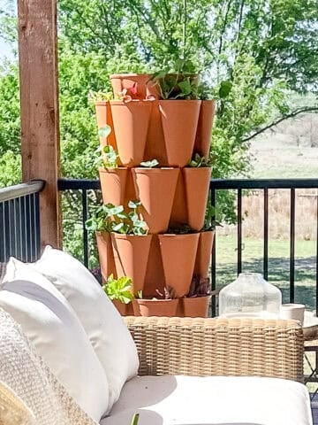 A greenstalk garden on a deck filled with mint and greens.