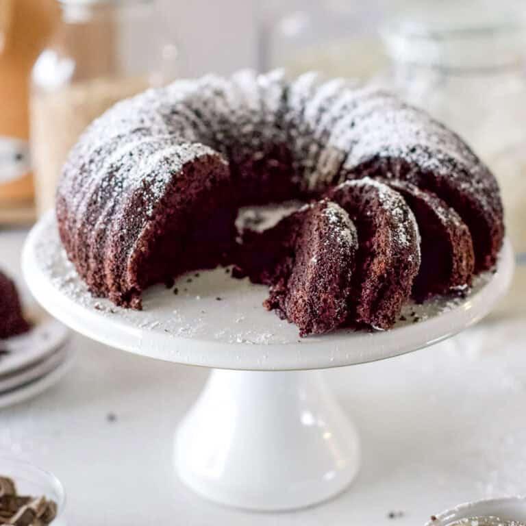 A chocolate sourdough bundt cake that has a few slices removed to show the inside of the cake.