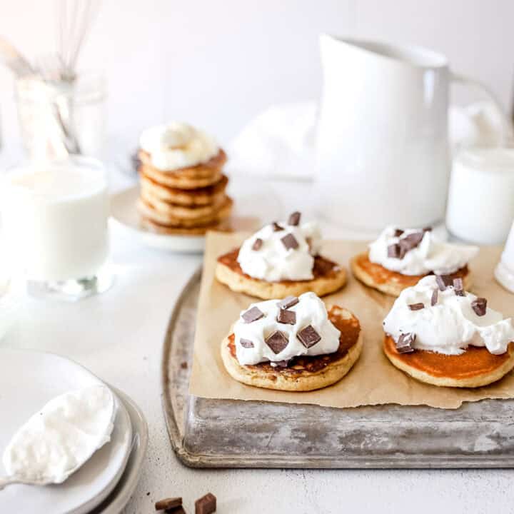 A picture of chocolate chip sourdough discard pancakes with whipped cream.