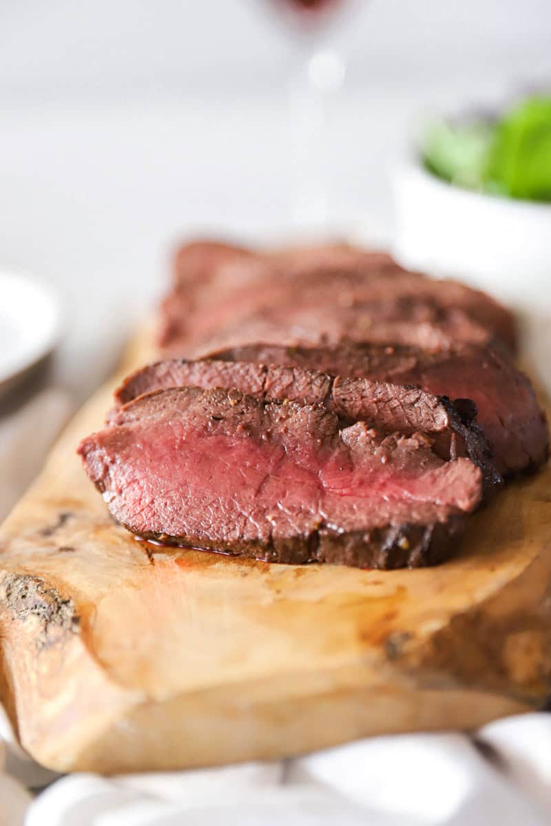 A detailed close-up image showing how do you cook venison steaks that gives an example of the red center and brown edges of a medium-rare steak.