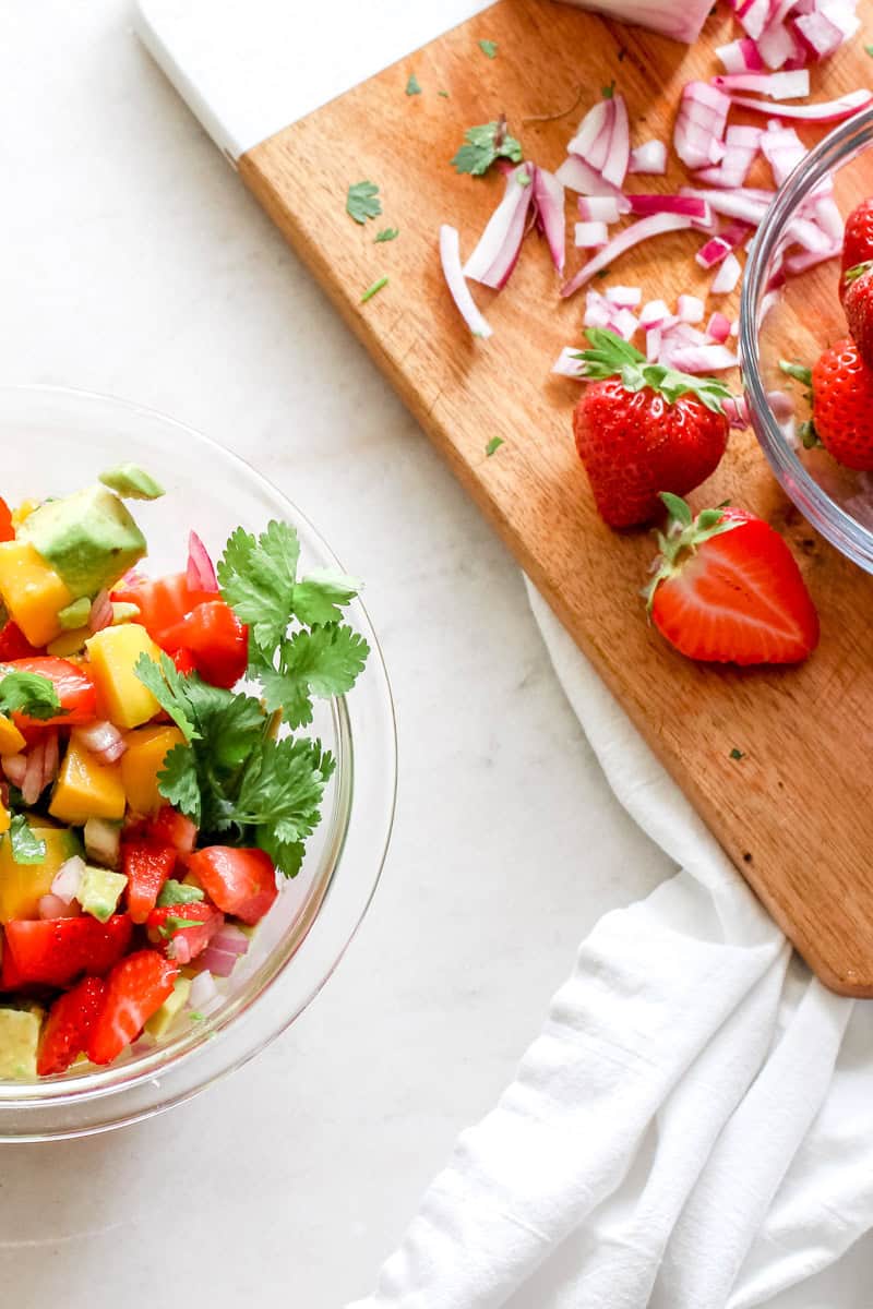 Step one of how to make mango salad is chopping the fruits and veggies into small pieces.