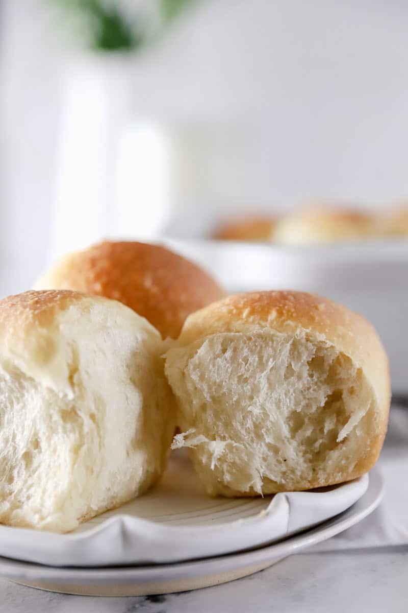 A close up view of pull apart sourdough dinner rolls on a plate.
